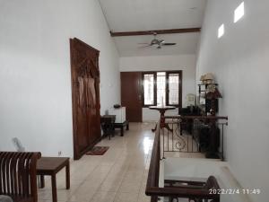 un salon avec des murs blancs et un plafond dans l'établissement Kelana 2 Nice Homestay (5 Bed Rooms) Semarang, à Semarang