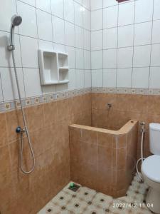 y baño con ducha, bañera y aseo. en Kelana 2 Nice Homestay (5 Bed Rooms) Semarang, en Semarang