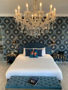 a bedroom with a large bed and a chandelier at La Concordia - Boutique Hotel in Panama City