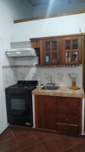 una cucina con piano cottura nero e lavandino di Alojamientos MiKa a Puerto Iguazú