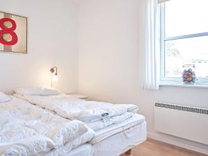 a bedroom with two white beds and a window at Holiday home Allinge XXII in Allinge