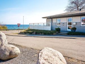 a house with two large rocks in front of the ocean at Holiday home Allinge XXII in Allinge