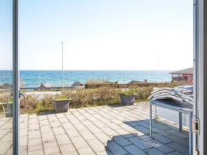 a patio with a bench and the ocean in the background at 4 person holiday home in Allinge-By Traum in Allinge