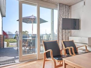 a room with a table and chairs and a sliding glass door at Holiday home Allinge XXI in Allinge