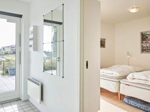 1 dormitorio con cama y espejo en Holiday home Allinge XXIII, en Allinge
