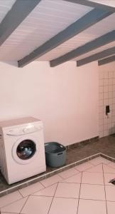 a washing machine in a room with a tile floor at Résidence BLEUE DE MER in Deshaies