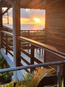 a view of the ocean from the porch of a house at Villa MIELéCAJOU, entre mer et montagne in Deshaies