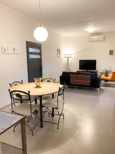 a dining room with a table and chairs and a television at Casa Vergara I in Villa Unión