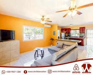 Wescot Villas Comfort في رواتان: غرفة معيشة مع أريكة وتلفزيون
