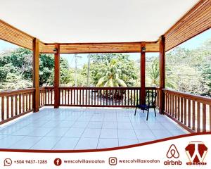 a screened in porch with a view of trees at Wescot Villas Sky View in Roatán