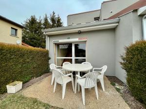 a white table and chairs in front of a building at Gîte Cayres, 3 pièces, 7 personnes - FR-1-582-341 in Cayres