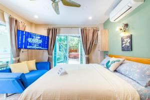 a bedroom with a large bed and a blue couch at Cozy House in Hua Hin, Thailand in Hua Hin