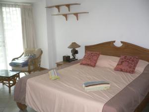 1 dormitorio con 1 cama grande y 1 silla en View Talay resort 5c 116 minimum stay 29 nights, en Pattaya South