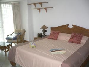 a bedroom with a large bed and a chair at View Talay resort 5c condo 115A minimum stay 29 nights in Pattaya South