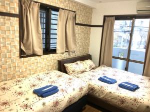 a bedroom with a bed with two blue pillows on it at Cozy Family room KY apartment in Naha