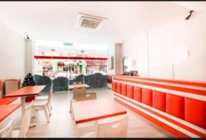 a restaurant with red benches and tables and chairs at DYAYA Hotel in Malacca