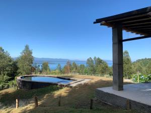 una piscina en medio de un campo con árboles en Casa Pucón Vista Lago y Volcan, en Pucón