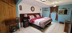 um quarto com uma cama e um relógio na parede em Hotel Vintage "Casa las Flores" em Quetzaltenango