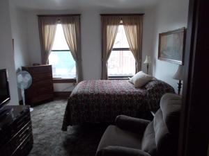 1 dormitorio con 1 cama, 1 sofá y 2 ventanas en Kellogg Rio Hotel en Kellogg
