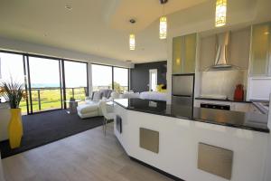 a kitchen and living room with a view of the ocean at Horizon Deluxe Apartments in Stanley