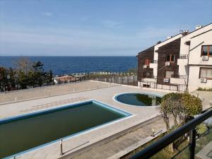 a swimming pool next to a building and the ocean at Apolon 2 in Sozopol