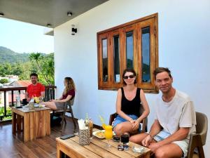 a man and a woman sitting on a table at Monkey Homestay & Bar in Tân Hiệp