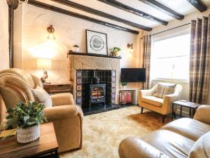 sala de estar con sofás y chimenea en The Nestling - 5 Victoria Cottages, en Bakewell