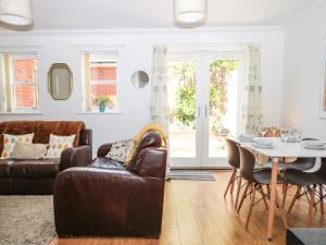 een woonkamer met een bank en een tafel bij Trinity Cottage in Christchurch