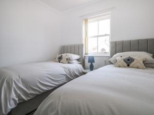 two beds sitting next to each other in a bedroom at Trinity Cottage in Christchurch