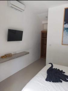 een slaapkamer met een bed en een tv aan de muur bij Villa Temple in Canggu +10 foto's