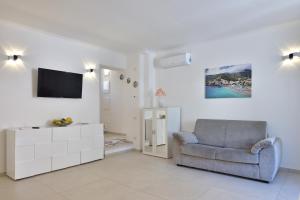 a living room with a chair and a television at Sirena Apartment in Minori