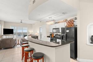 a kitchen and living room with a counter and stools at Sunrise Beach Resort V in Panama City Beach
