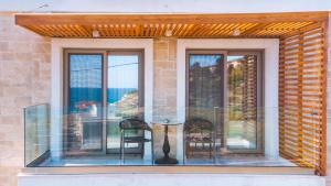 Pachia Ammos的住宿－Thronos Aqua Residence a Sea View Luxury Villa，阳台配有2把椅子和桌子