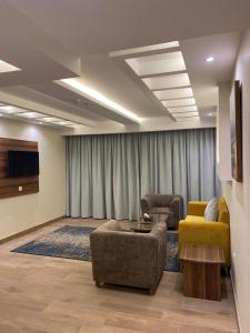 a living room with two chairs and a couch and a tv at Lahdat in Jeddah