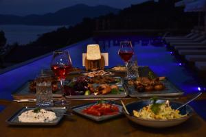 einen Tisch mit Teller mit Speisen und Gläsern Wein in der Unterkunft Vista Del Amor Faralya in Fethiye