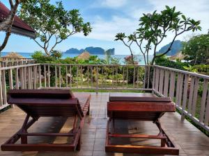 two benches on a deck with a view of the ocean at Paradise Pearl Bungalows in Phi Phi Islands