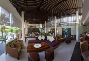 a lobby of a resort with couches and chairs at Dhevatara Beach Hotel in Grand'Anse Praslin