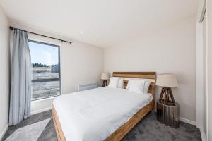 a bedroom with a large bed and a window at Akin Tekapo in Lake Tekapo