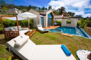 un patio trasero con piscina y una villa en Vista Del Amor Faralya, en Fethiye