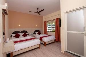 um quarto de hotel com duas camas e uma janela em The Country Yard em Pokhara