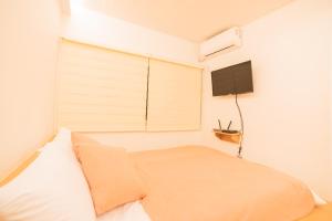 a bedroom with a bed and a flat screen tv at Huayuanhouse HQ in hongdae in Seoul