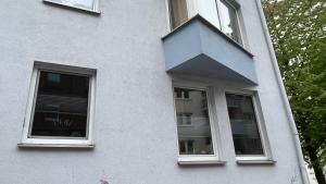 a white building with two windows and a roof at Charaktervolle Whg. mitten in Kassel inkl.Parkplatz in Kassel