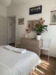 Un dormitorio con una cama blanca y un espejo. en Igea Mare, en Bellaria-Igea Marina