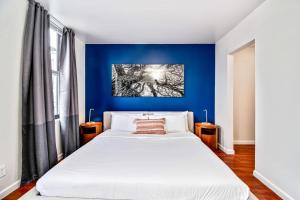 1 dormitorio con 1 cama blanca grande y pared azul en Gorgeous 2BD next to the convention center and reading terminal en Filadelfia