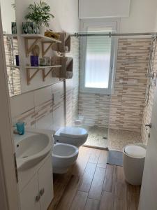 Un baño con dos inodoros y una ducha. en Igea Mare, en Bellaria-Igea Marina