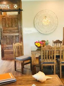 una sala da pranzo con tavolo, sedie e cesto di frutta di Grand Serene Lakeside Bali Style Villa a Cyberjaya
