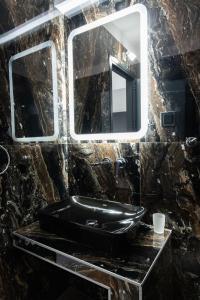 a bathroom with a black sink and a mirror at Aeonian Luxury Suites Asprovalta, Adults Only & Kids 12 Plus in Asprovalta