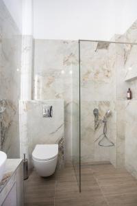 a bathroom with a toilet and a glass shower at Aeonian Luxury Suites Asprovalta, Adults Only & Kids 12 Plus in Asprovalta