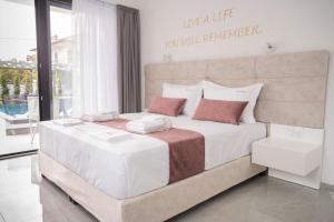 a bedroom with a large bed with white sheets and red pillows at Aeonian Luxury Suites Asprovalta, Adults Only & Kids 12 Plus in Asprovalta