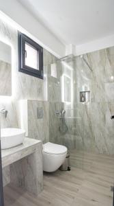 a bathroom with a toilet and a sink and a shower at Aeonian Luxury Suites Asprovalta, Adults Only & Kids 12 Plus in Asprovalta